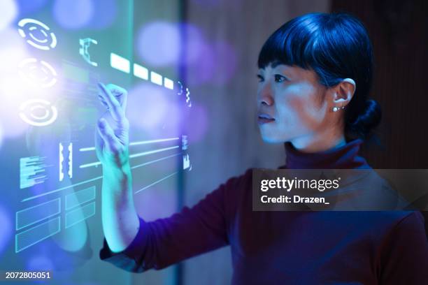 futuristisches büro mit japanischer reifer geschäftsfrau, die am touchscreen arbeitet und entscheidungen trifft - asiatische kultur stock-fotos und bilder