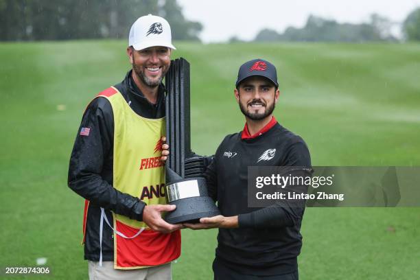 Abraham Ancer of FIREBALLS GC and his caddy celebrates with the trophy after win the first place during day three of the LIV Golf Invitational - Hong...