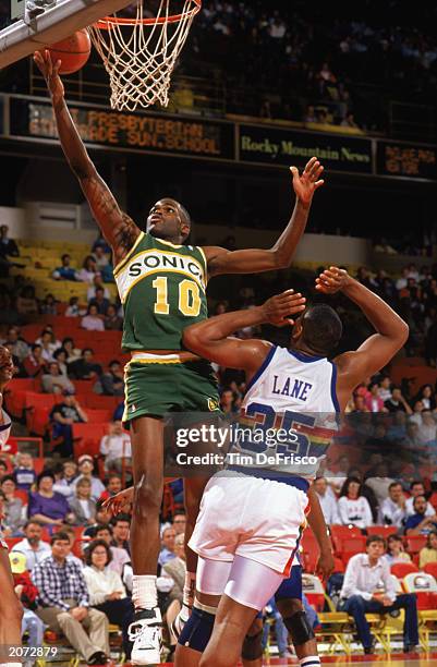 Nate McMillan of the Seattle Supersonics goes for a layup past Jerome Lane of the Denver Nuggets during a game in the 1989-1990 NBA season at...