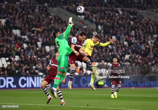 Alphonse Areola of West Ham United prepares to make a save whilst under pressure from teammate Nayef Aguerd and Jacob Bruun Larsen of Burnley during...