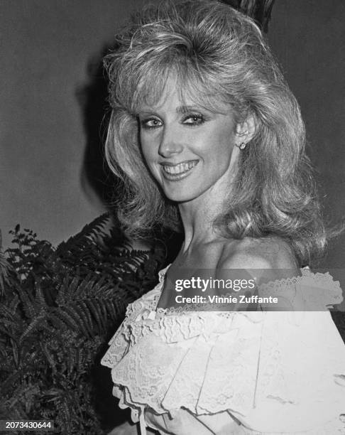 American actress Morgan Fairchild, wearing a white off-shoulder outfit, United States, circa 1983.