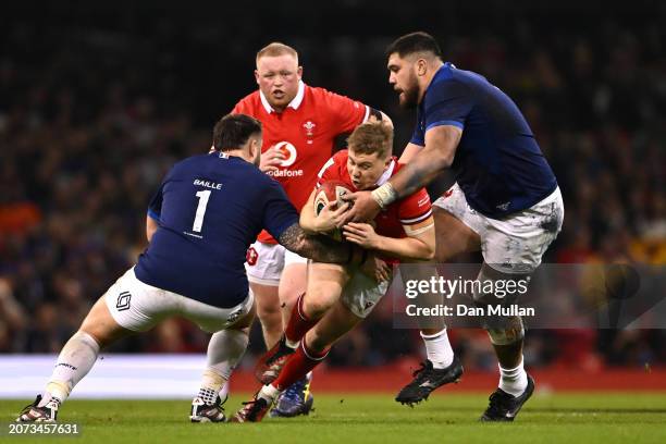 Sam Costelow of Wales is tackled by Cyril Baille and Emmanuel Meafou of France during the Guinness Six Nations 2024 match between Wales and France at...