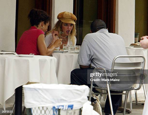 Singer Britney Spears eats lunch with some unidentified friends in SoHo June 11, 2003 in New York City.