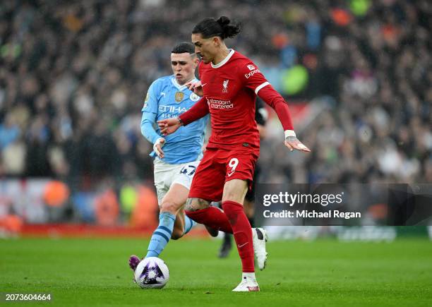 Darwin Nunez of Liverpool runs with the ball whilst under pressure from Phil Foden of Manchester City during the Premier League match between...