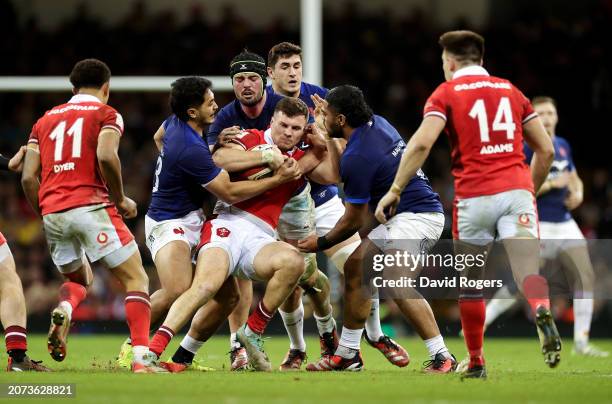 Mason Grady of Wales is tackled by Yoram Moefana, Gregory Alldritt and Peato Mauvaka of France during the Guinness Six Nations 2024 match between...