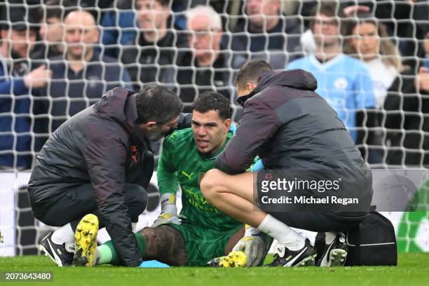 Ederson of Manchester City receives medical treatment after sustaining an injury and is later substituted off during the Premier League match between...