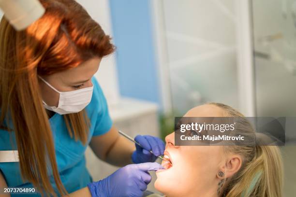 young woman having her teeth checked during appointment at dentist's office. s - plaque remover stock pictures, royalty-free photos & images