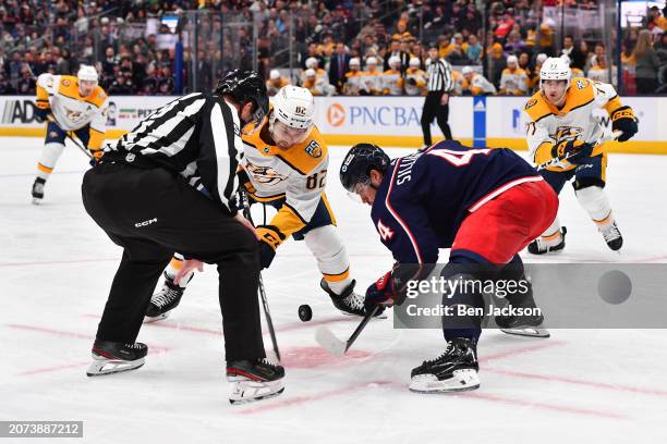 Tommy Novak of the Nashville Predators and Cole Sillinger of the Columbus Blue Jackets battle for the puck in a face-off during the second period of...