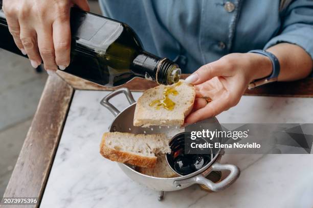 women's hands with traditional antipasti in a local italian restaurant fresh bread with organic olives and local fresh olive oil - huile de table photos et images de collection