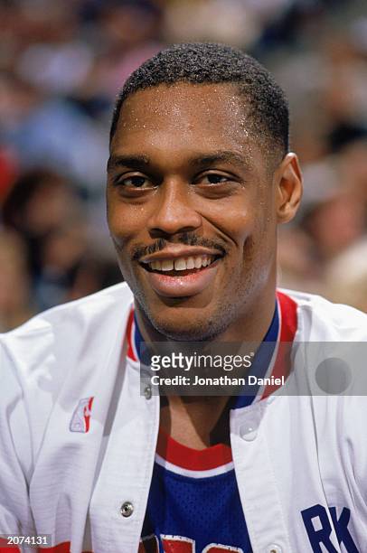 Rick Mahorn of the Detroit Pistons smiles as he sits on the bench in a game during the 1989-1990 NBA season.