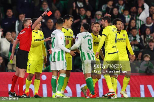 Match referee Hernandez Hernandez shows Ezequiel Avila of Real Betis and Gerard Moreno of Villarreal CF a red card during the LaLiga EA Sports match...