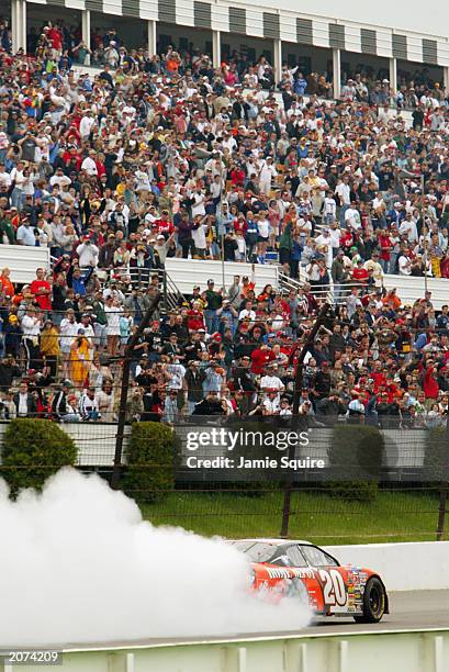 Tony Stewart, driver of the Joe Gibbs Racing Chevrolet Monte Carlo, performs a burn-out in front of the cheering crowd while celebrating his victory...