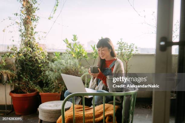 japanese woman having a video call - balcony stock pictures, royalty-free photos & images