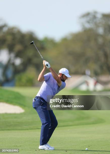 This image is part of a sequence; Scottie Scheffler of The United States plays a 3-wood second shot on the par five 12th hole during the final round...