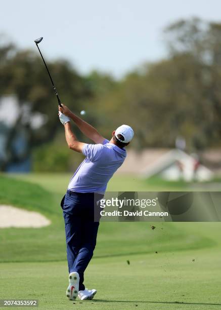 This image is part of a sequence; Scottie Scheffler of The United States plays a 3-wood second shot on the par five 12th hole during the final round...