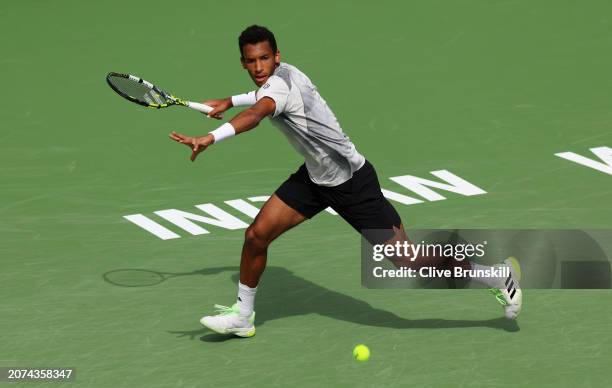 Felix Auger-Aliassime of Canada plays a forehand against Carlos Alcaraz of Spain in their third round match during the BNP Paribas Open at Indian...