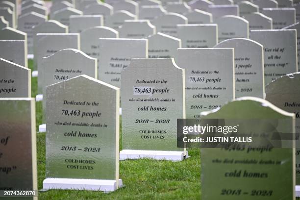 Photograph taken on March 13, 2024 shows gravestones reading "Dedicated to the 70 463 people who died avoidable death in cold homes 2013-2023, cold...