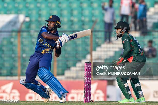 Sri Lanka's Janith Liyanage plays a shot as Bangladesh's Mushfiqur Rahim watches during the first one-day international cricket match between...