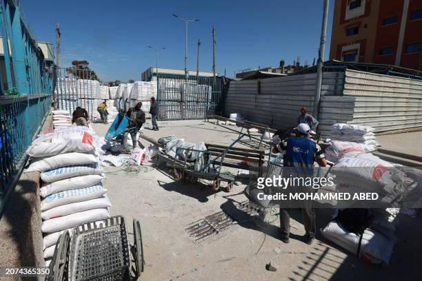 Workers are pictured at a UNRWA warehouse/distribution centre in Rafah, in the southern Gaza Strip, which was partially hit by an strike on March 13...