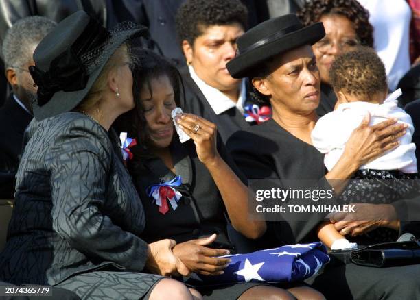 Melodie Homer , with the American Flag on her lap, is comforted by a family friend following a memorial service 28 September 2001 at Meadow View...