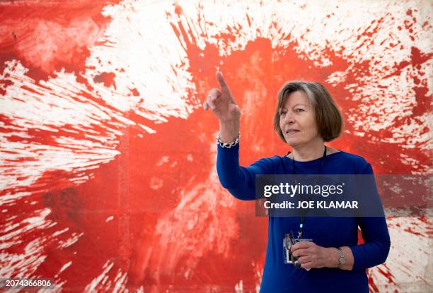 Exhibition curator and art historian Eva Badura-Triska speaks in front of a painting by Hermann Nitsch, a leading figure of Viennese Actionism, whose...