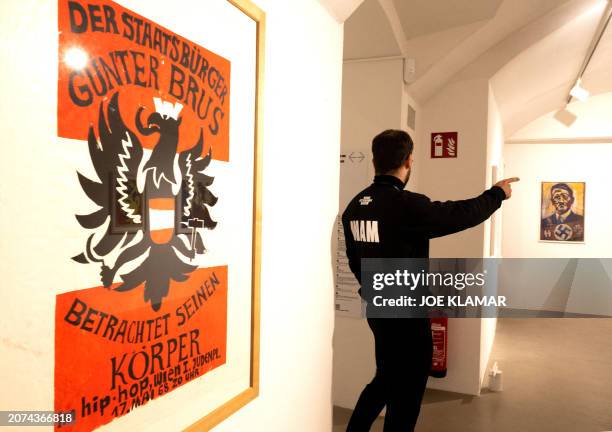 An employee walks past Guenter Brus' silkscreen prints during a press event on March 13, 2024 at the new Museum of Vienna Actionism two days before...