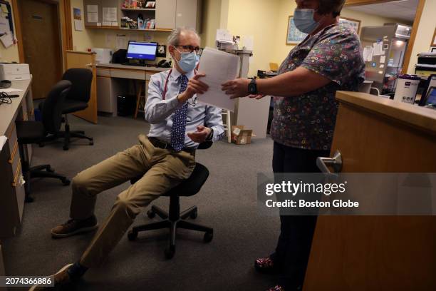 Lakeville, MA Pediatrician Dr. Aaron Bornstein, left, talks with registered medical assistant Tamara Rivera about a patients medication and billing...