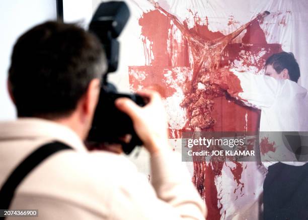 Journalists takes a photograph of a photograph documenting Hermann Nitsch, a leading figure of Viennese Actionism, whose art encompassed wide-scale...