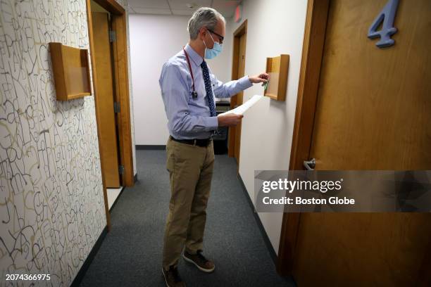 Lakeville, MA Pediatrician Dr. Aaron Bornstein picks up a file before visiting a patient at Middleboro Pediatrics.