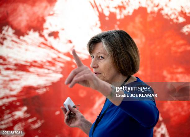 Exhibition curator and art historian Eva Badura-Triska speaks in front of a painting by Hermann Nitsch, a leading figure of Viennese Actionism, whose...