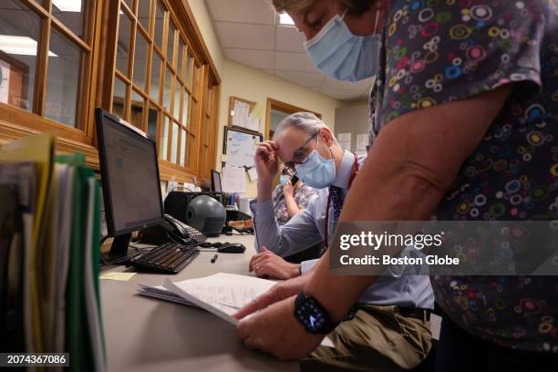 Lakeville, MA Pediatrician Dr. Aaron Bornstein, left, talks with registered medical assistant Tamara Rivera about a patients medication and billing...