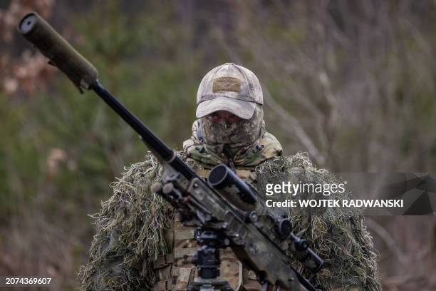 Camouflaged British soldier is pictured ahead of the start of a practice during the visit of Polish Defence Minister and Britain's Defence Secretary...