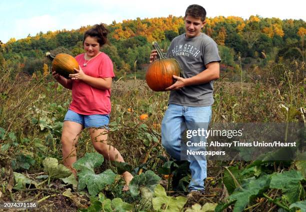 Twelve-year-old Casey Lizza, left, and her 16-year-old brother Peter Lizza pick pumpkins at Pumpkin Pete's on Route 30 in Schoharie, NY Friday Oct....