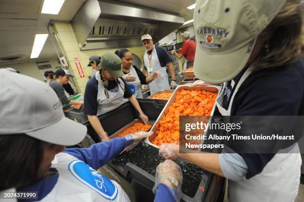 Volunteer chef Mark McDonald, center,oversees a group of volunteers prepping carrots for the Equinox Thanksgiving Dinner at the Empire State Plaza in...