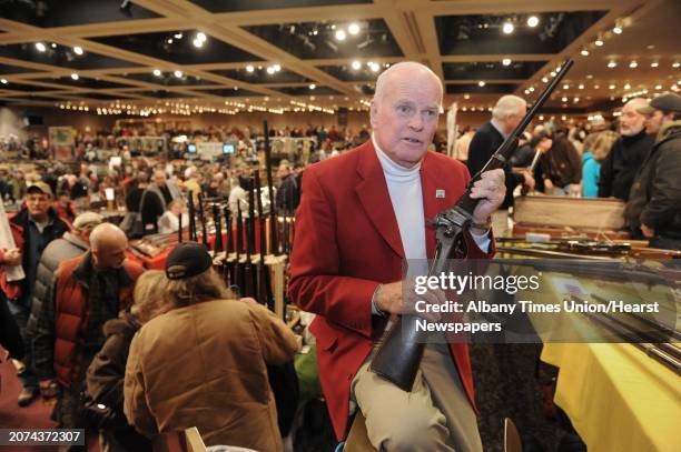 Show board of directors member Doug Roberts holds a 1862 Sharps single shot military rifle during the New York State Arms Collectors Show at the...