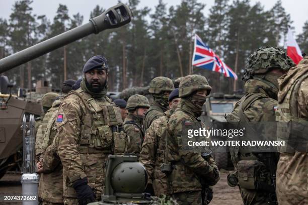 Soldiers of the NATO Response Force await for the start of a practice during the visit of Polish Defence Minister and Britain's Defence Secretary on...
