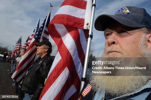 Viet Nam war veteran Dean Courter, right, joins other members of the Patriot Guard Riders in displaying the colors during a ceremony to remember...