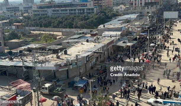 An aerial view as Palestinians at Nuseirat refugee camp doing their Ramadan shopping at the bazaar established between the destroyed buildings as...