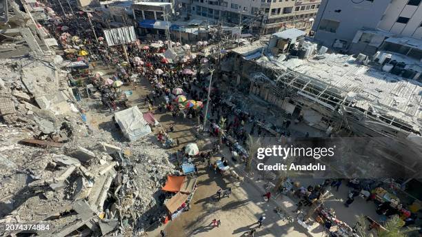 An aerial view as Palestinians at Nuseirat refugee camp doing their Ramadan shopping at the bazaar established between the destroyed buildings as...