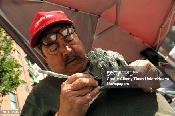 Artis Dennis Gervasio of Albany touches up one of his duct tape sculptures of a Buffalo on sale during the 2013 LarkFest on Saturday Sept. 21, 2013...