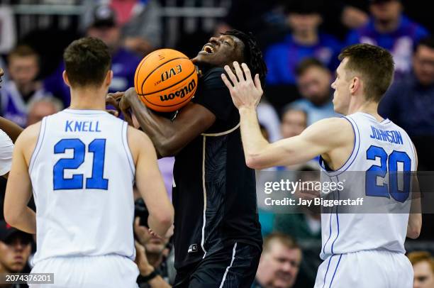 Thierno Sylla of the UCF Knights grabs a rebound against Trevin Knell and Spencer Johnson of the Brigham Young Cougars during the first half of the...