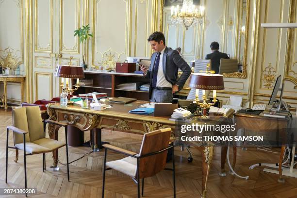 French Prime minister Gabriel Attal looks at his phone in his office at the Hotel Matignon, in Paris, on March 13, 2024. Secularism is "threatened...