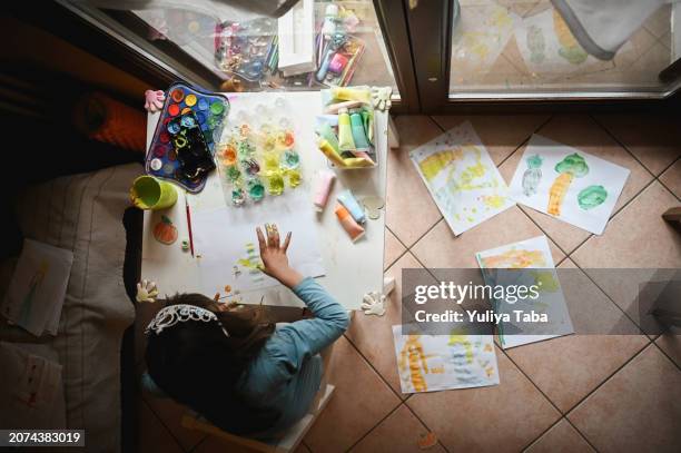 blick von oben auf ein kleines mädchen, das fingermalerei genießt. - 4 girl finger paint stock-fotos und bilder