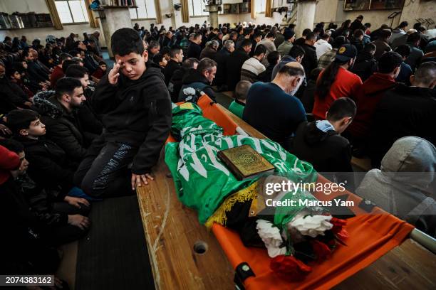 Nasseem Majdi center, sits beside the body his friend Amro Najjar who was killed by Israeli forces during an incursion the day before, during a...