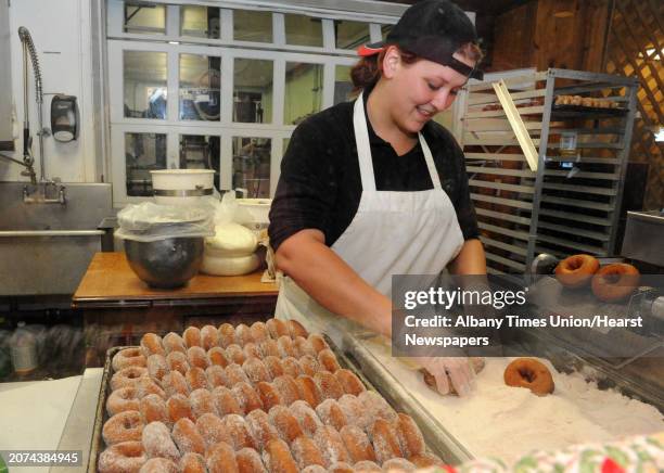 Crystal Wells puts powdered sugar on hot cider donuts during Goold Orchards 27th Annual Apple Festival & Craft Show on Saturday Oct. 10, 2015 in...