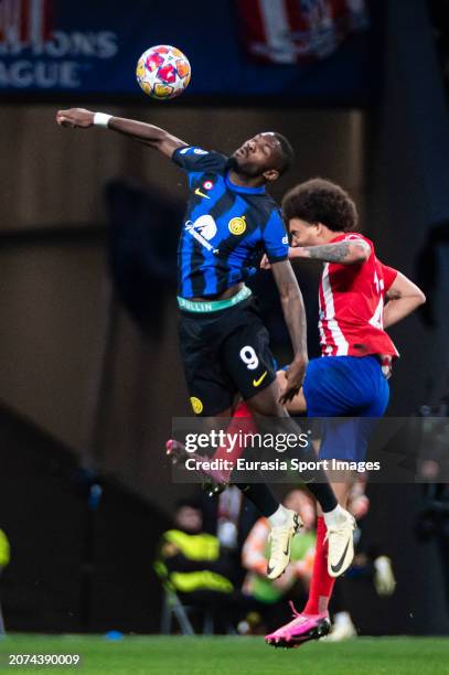 Marcus Thuram of Internazionale fights for heading the ball with Axel Witsel of Atletico de Madrid during the UEFA Champions League 2023/24 round of...