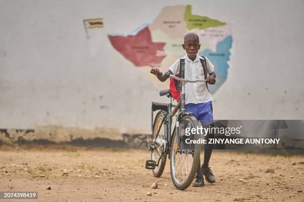 Joaquim Homera, a primary school learner heads to park his bicycle at school at Mabale primary school near Hwange National Park in Hwange on March 8,...