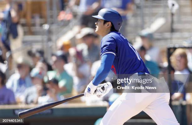 Shohei Ohtani of the Los Angeles Dodgers flies out in the first inning of a spring training baseball game against the Seattle Mariners in Glendale,...