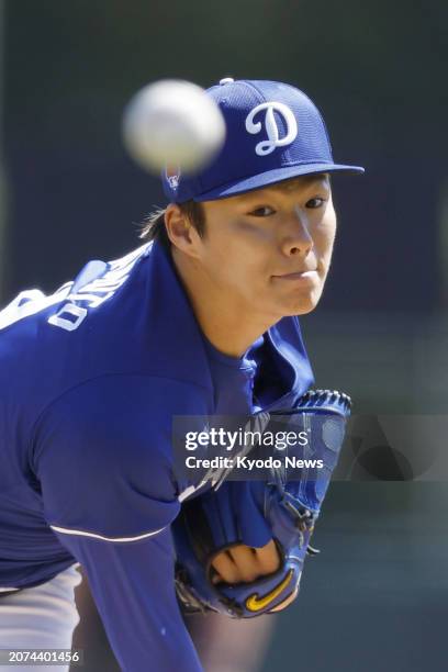 Yoshinobu Yamamoto of the Los Angeles Dodgers pitches in a spring training baseball game against the Seattle Mariners in Glendale, Arizona, on March...