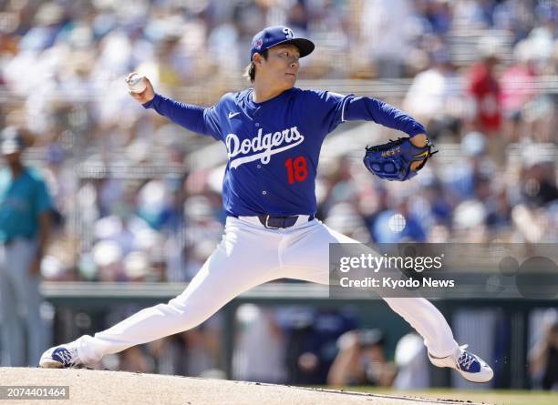Yoshinobu Yamamoto of the Los Angeles Dodgers pitches in a spring training baseball game against the Seattle Mariners in Glendale, Arizona, on March...